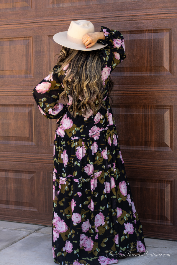 "Midnight Blossom Black Floral Maxi Long Sleeve Dress from Timeless Threads Boutique featuring a rich black fabric with elegant floral patterns, ideal for fall with its flowing silhouette and long sleeves."