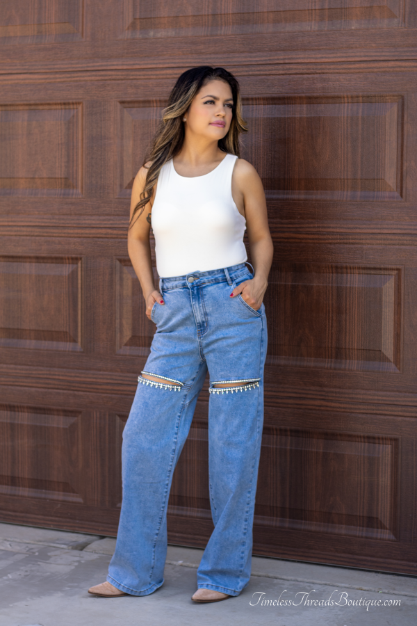 "Shimmer Cut Light Washed Rhinestone Front Denim Jeans with above-the-knee slits adorned with rhinestones and a heart-shaped detail on the back, offering a trendy and glamorous look."