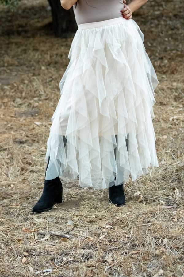 A shell-colored spiral ruffled tulle midi skirt, showcasing delicate layers of soft tulle that create a flowing, elegant silhouette. Perfect for spring and summer occasions, this skirt adds a romantic touch to any outfit.