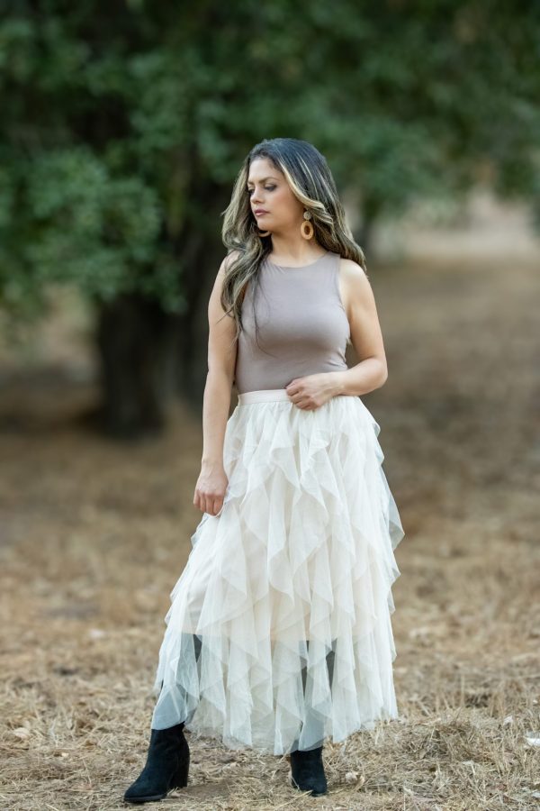 A shell-colored spiral ruffled tulle midi skirt, showcasing delicate layers of soft tulle that create a flowing, elegant silhouette. Perfect for spring and summer occasions, this skirt adds a romantic touch to any outfit.