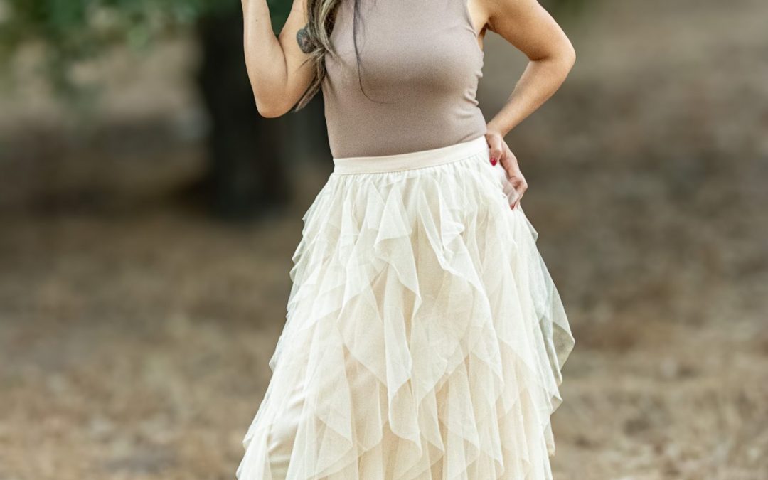 A shell-colored spiral ruffled tulle midi skirt, showcasing delicate layers of soft tulle that create a flowing, elegant silhouette. Perfect for spring and summer occasions, this skirt adds a romantic touch to any outfit.