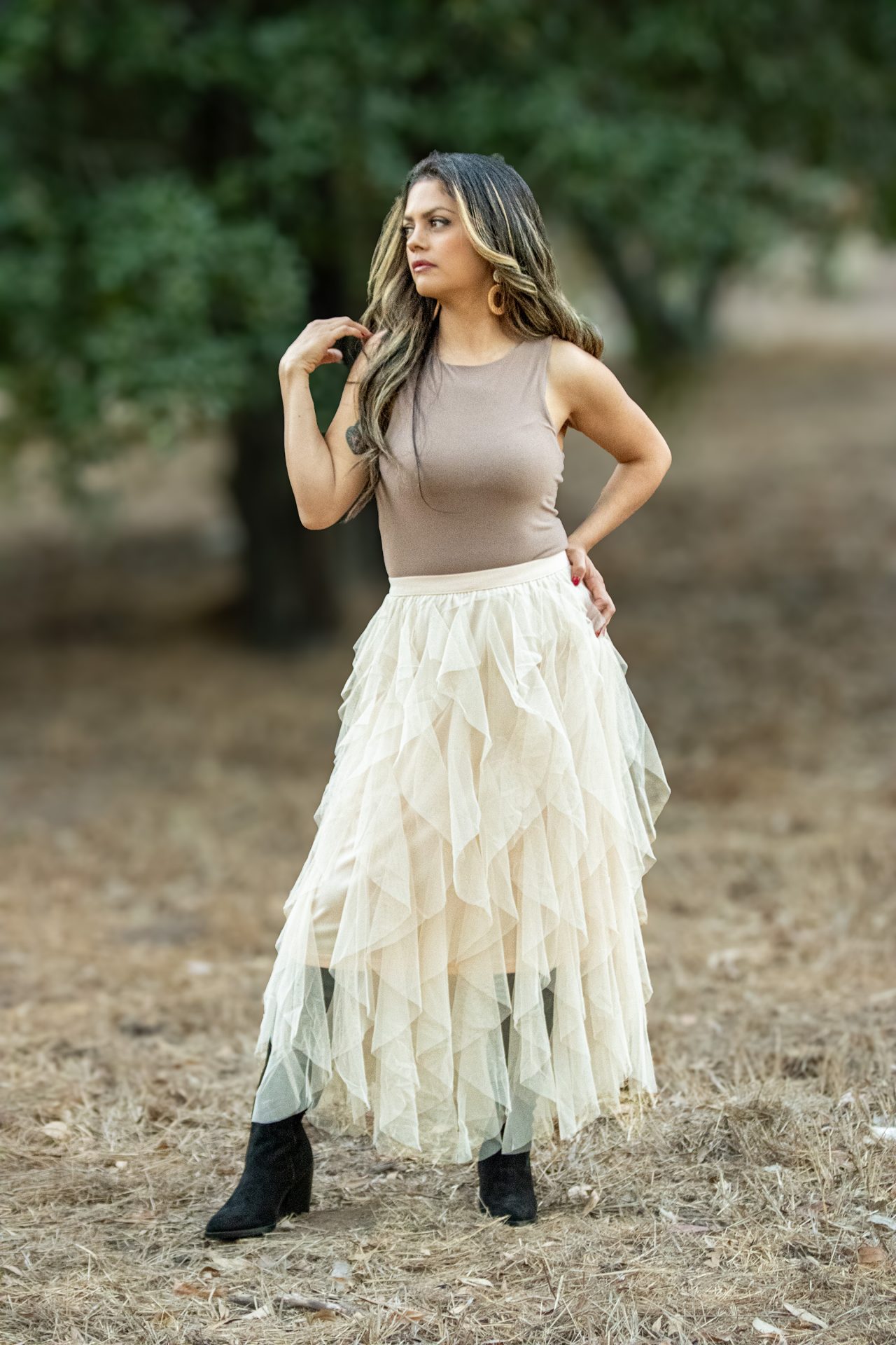 A shell-colored spiral ruffled tulle midi skirt, showcasing delicate layers of soft tulle that create a flowing, elegant silhouette. Perfect for spring and summer occasions, this skirt adds a romantic touch to any outfit.