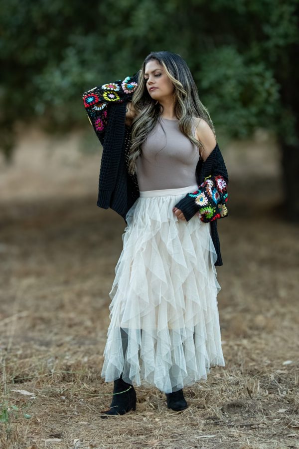 A cozy black knit long sleeve cardigan featuring vibrant multi-colored patterns, perfect for fall layering. This stylish cardigan is ideal for pairing with boots and adds a chic touch to any outfit.