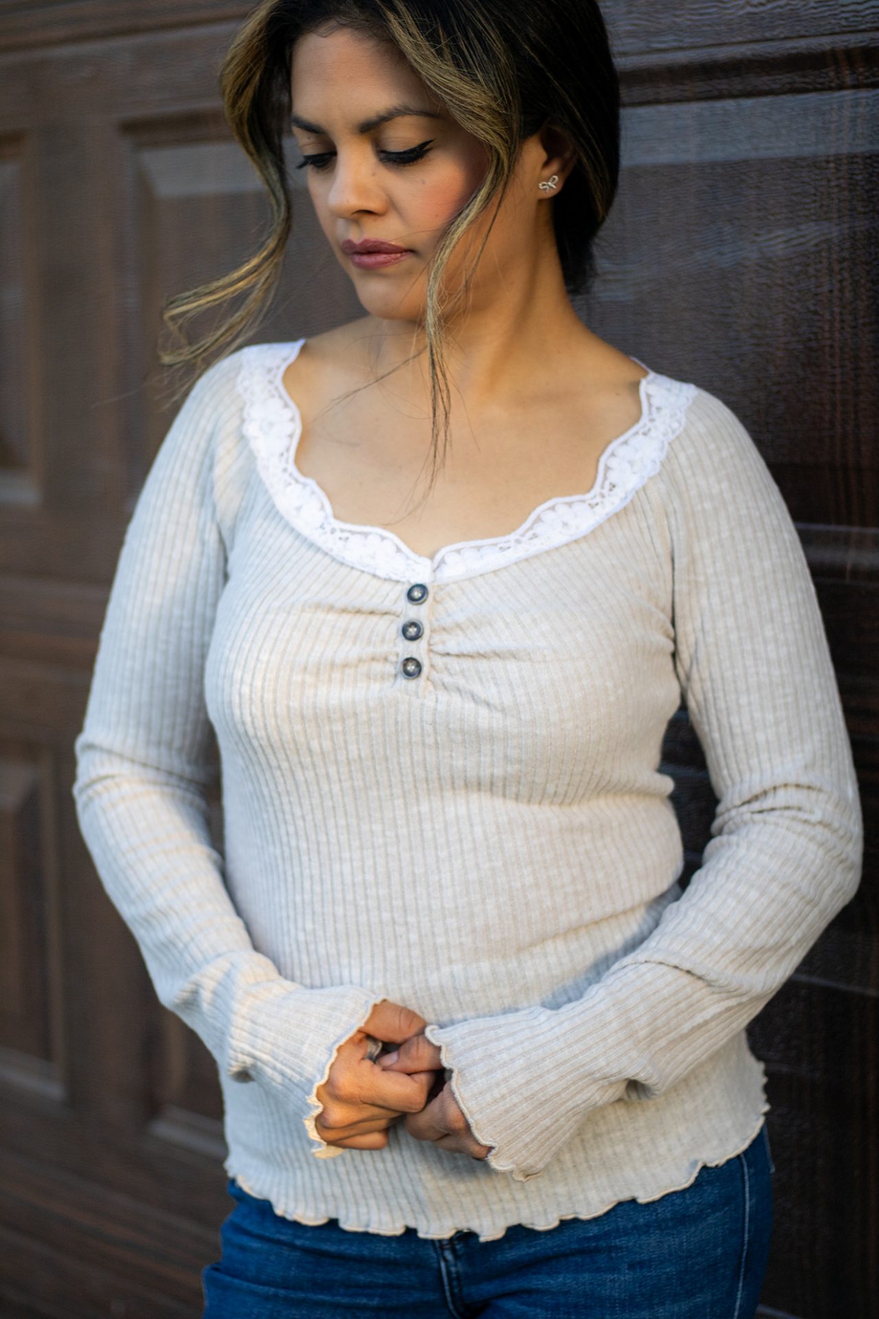 Light beige ribbed long sleeve top with white lace trim neckline, scalloped hem, and button-front detail shown in natural lighting.