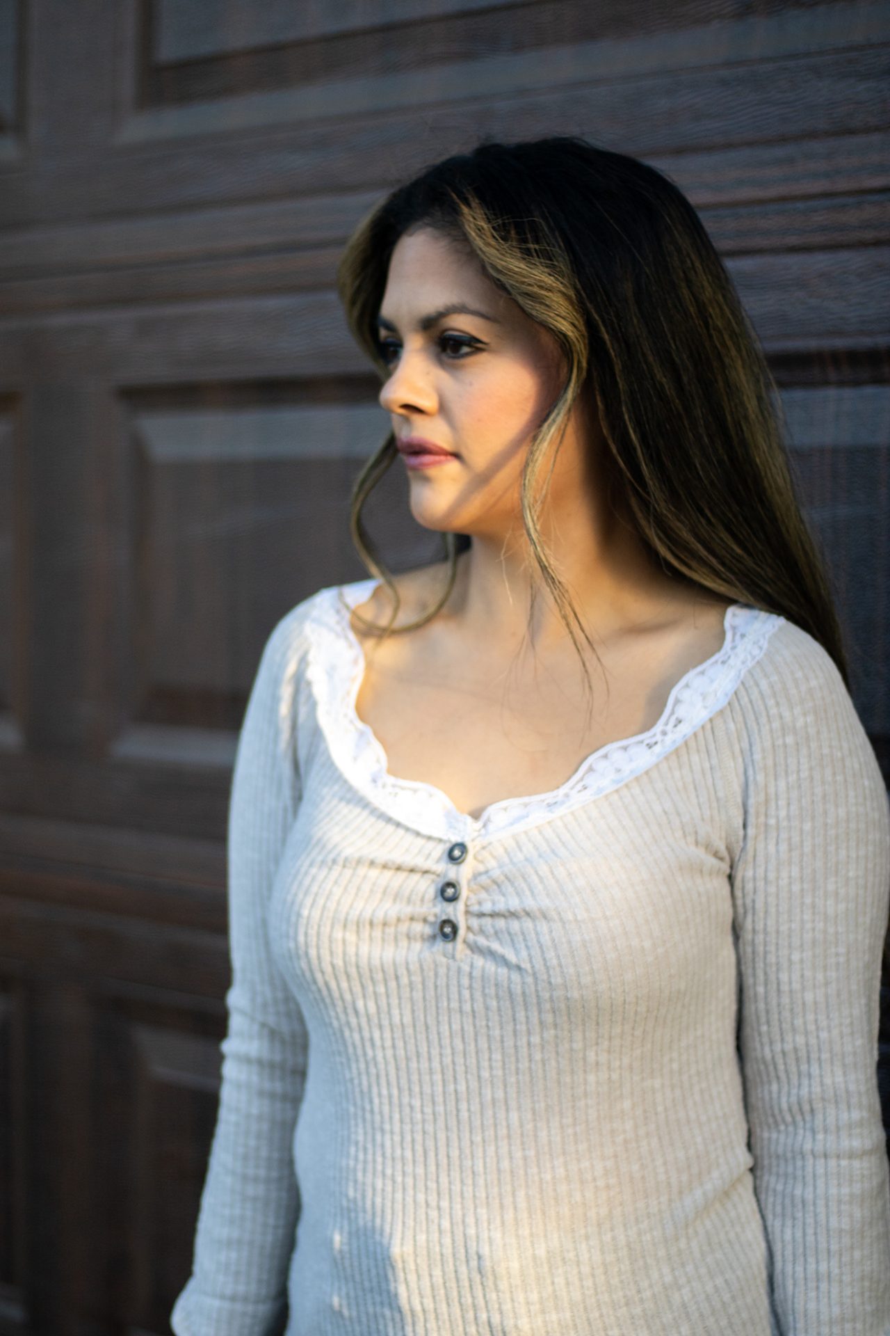 Light beige ribbed long sleeve top with white lace trim neckline, scalloped hem, and button-front detail shown in natural lighting.