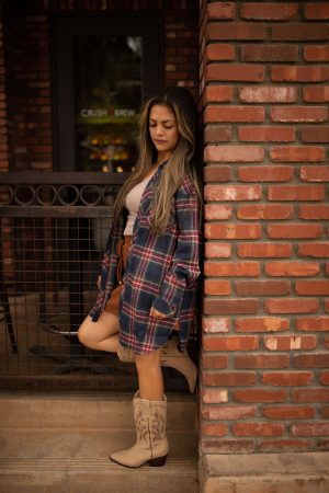 Blue and red plaid oversized tunic top with long sleeves and a relaxed button-front design shown worn for a casual, comfortable look.