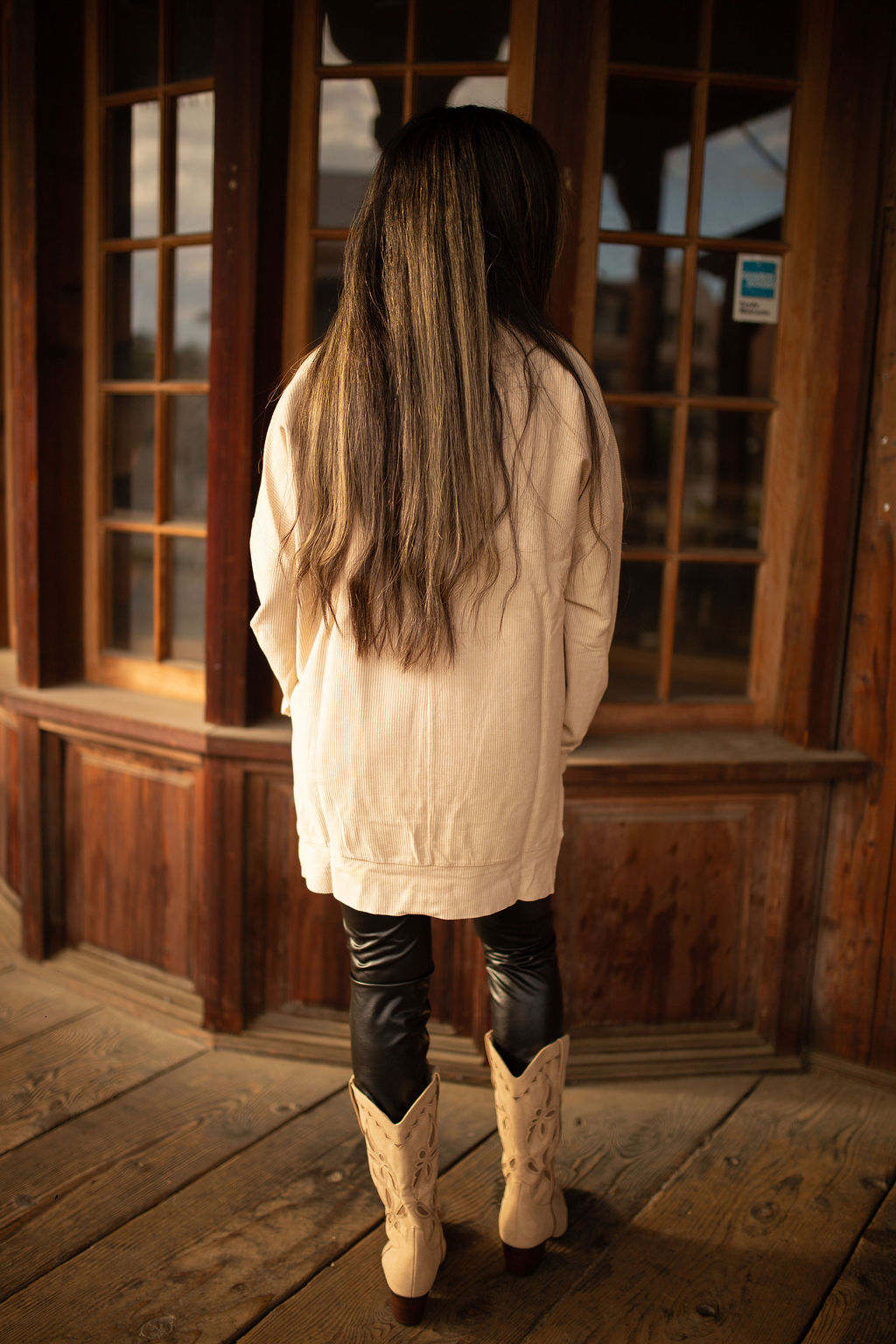 Taupe vintage-washed corded pullover with ribbed texture, crew neckline, and hi-lo hem with side slits shown in natural outdoor lighting.