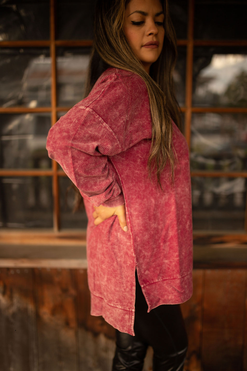 Maroon vintage-washed corded pullover with ribbed texture, crew neckline, and hi-lo hem with side slits displayed in natural outdoor lighting.