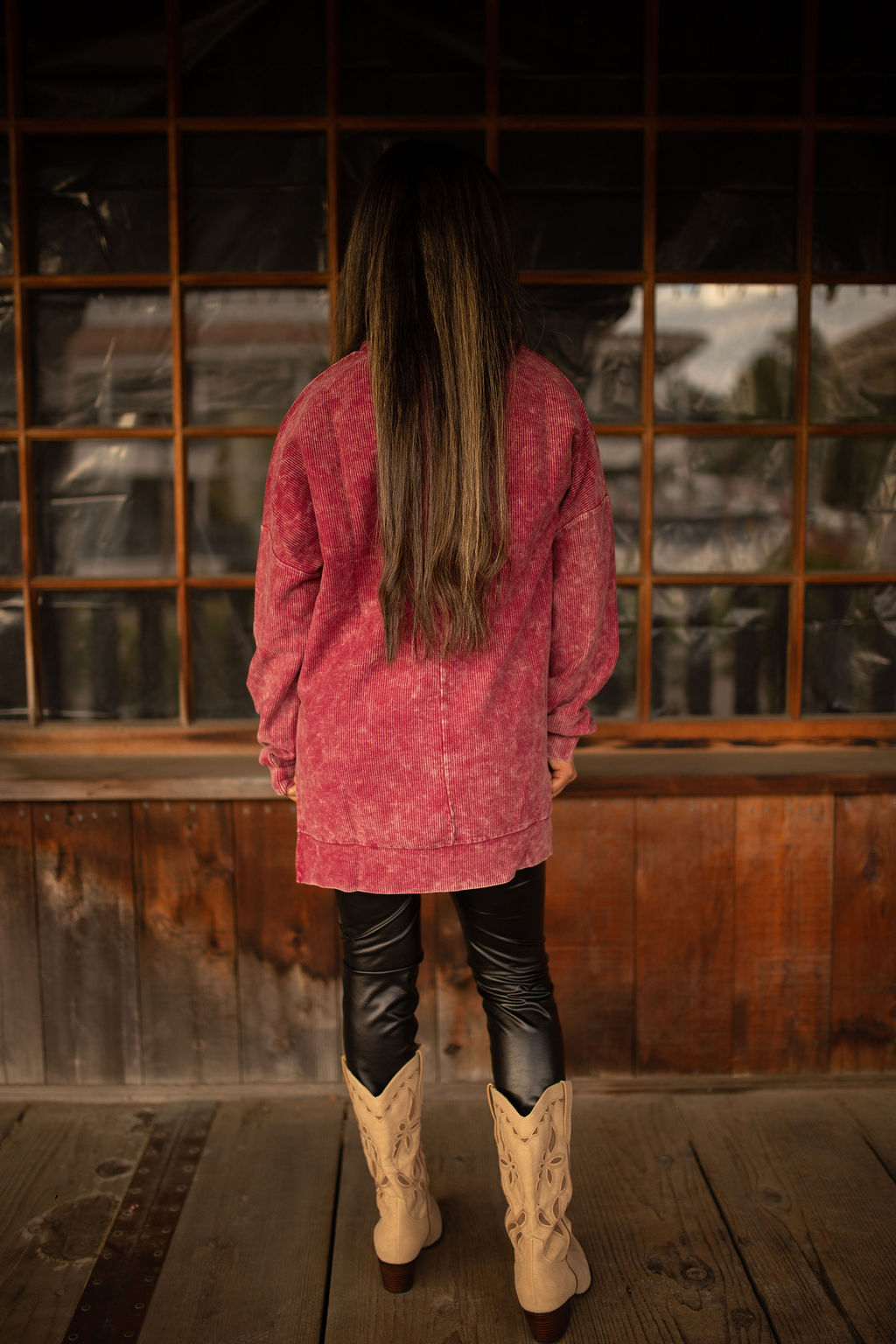 Maroon vintage-washed corded pullover with ribbed texture, crew neckline, and hi-lo hem with side slits displayed in natural outdoor lighting.