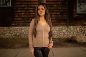 Taupe ribbed long sleeve top with lace trim and front buttons, displayed outdoors in natural lighting.