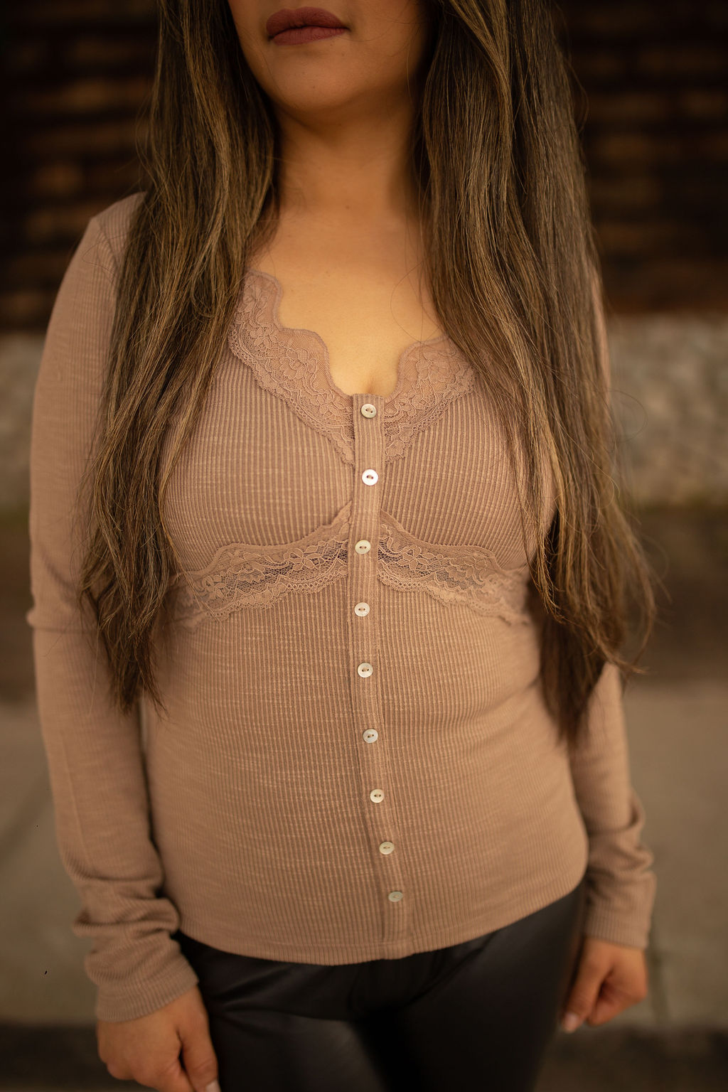 Taupe ribbed long sleeve top with lace trim and front buttons, displayed outdoors in natural lighting.