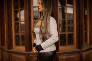 Soft ribbed long sleeve top featuring warm-toned color block stripes across the chest and sleeves, displayed in natural outdoor lighting.